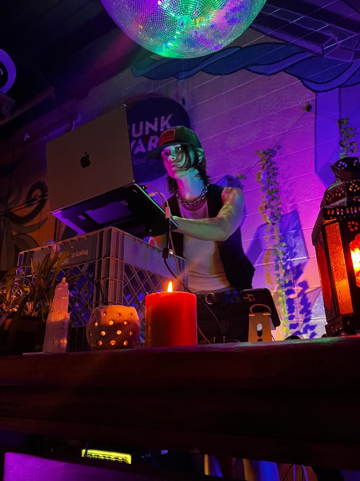 Alondra Kingman DJ set behind a laptop and candlelight